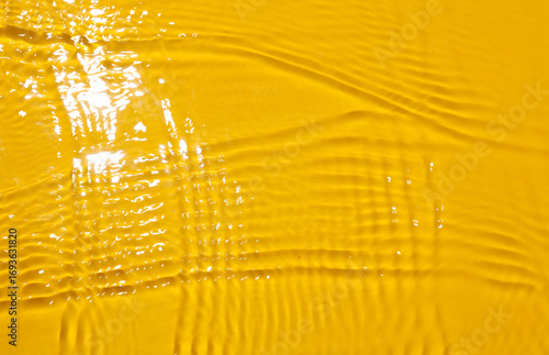 Wavy water texture with sun light on yellow background