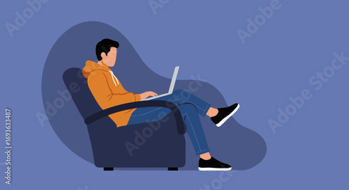 Young man sitting comfortably in an armchair, focused on working remotely or studying on his laptop at home.