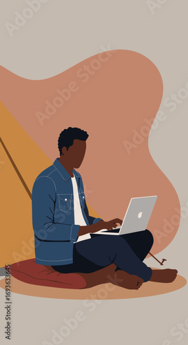 Focused man working remotely on laptop while sitting comfortably, embodying digital nomad lifestyle and flexible work concepts.