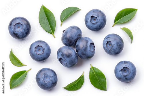 Fresh blueberries and green leaves scattered on white background