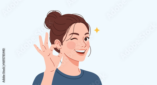 A young woman with her hair pulled up in a bun winks and gives a perfect gesture with her fingers