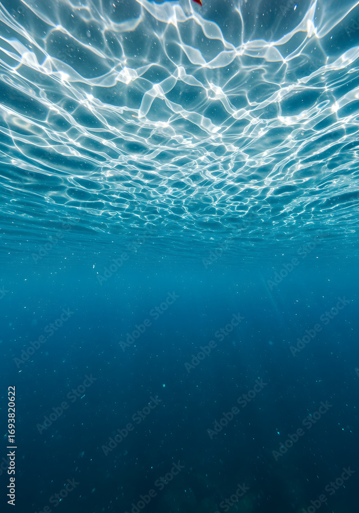 Fototapeta premium Underwater Ocean Sunlight Reflections Blue Water Surface Ripples, Sunlight Patterns, Abstract Textured Background.