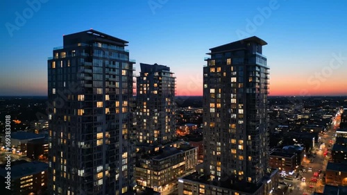 Wallpaper Mural Illuminated high-rise residential towers glowing against a vibrant twilight sky, showcasing modern urban architecture and downtown city life Torontodigital.ca