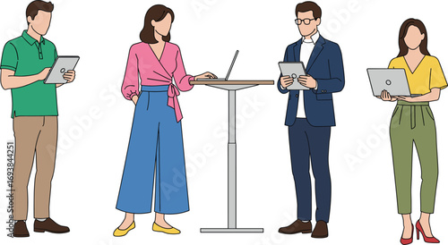 Young business professionals working together standing around high table using laptops and tablets, representing teamwork, collaboration, and modern office technology concept.