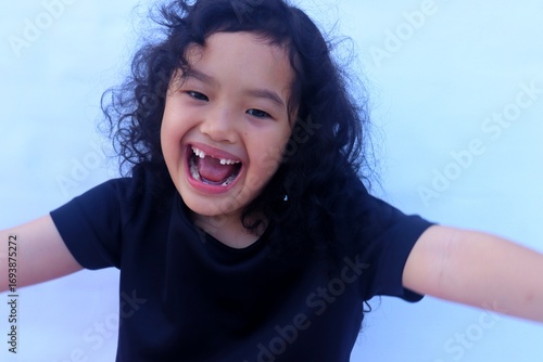 The expression of an Asian girl with a cheerful face and a big smile.