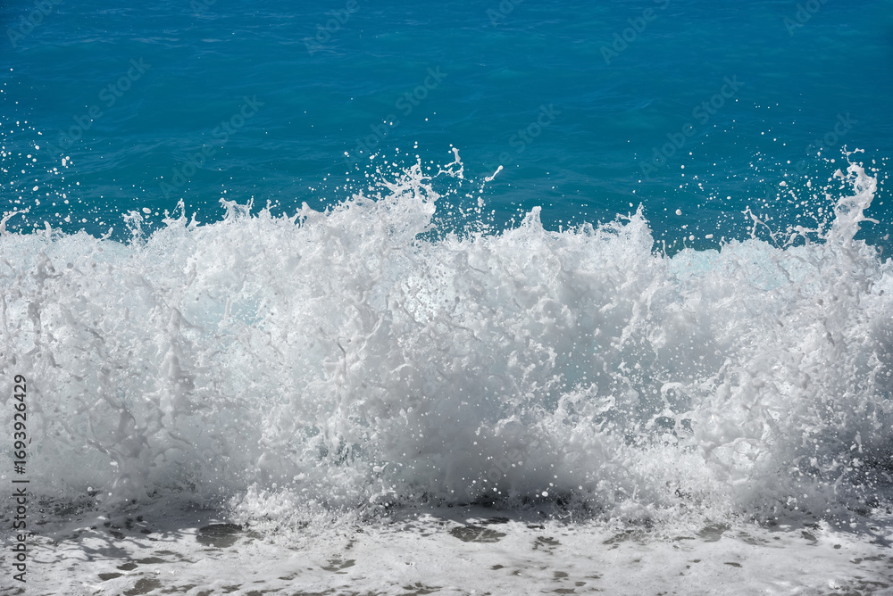 Obraz premium Close-up of a foaming wave breaking on the pebble beach. Rough sea. 
