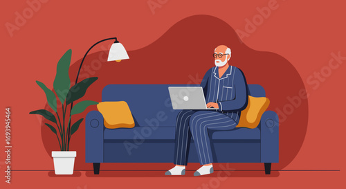 Comfortable senior man in pajamas using a laptop on a sofa at home. Depicts remote work, digital lifestyle, or online learning for older adults.