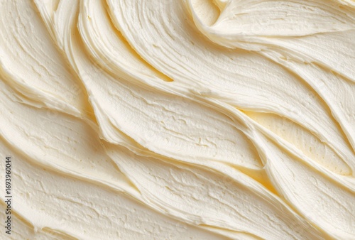 Close up surface of vanilla cream creates abstract lines and waves with soft texture. The detail shows food background patterns for design and creative use.
