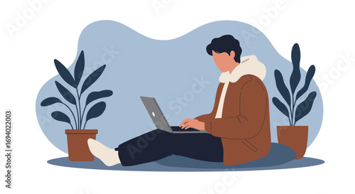 Young man working remotely on a laptop in a relaxed, modern indoor setting with plants, showcasing productivity and a flexible lifestyle.