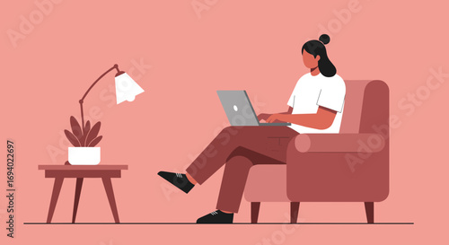 Remote worker focused on laptop in a cozy armchair. Depicts modern work flexibility, online education, freelance, and digital lifestyle in a comfortable home office.