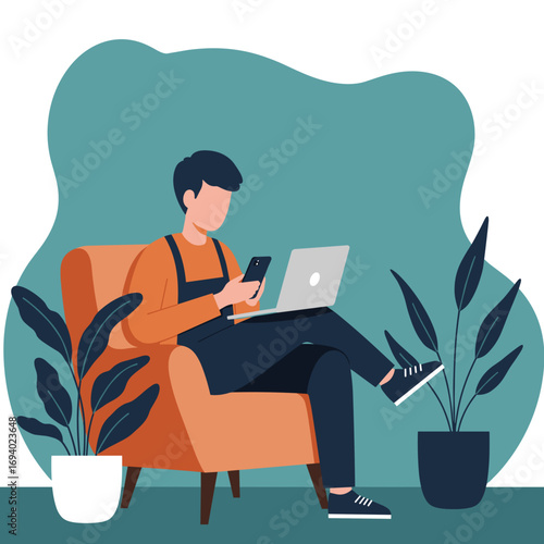 Young man working remotely, comfortably using a laptop and smartphone in a cozy armchair at home. Represents flexible work, technology, and modern lifestyle.