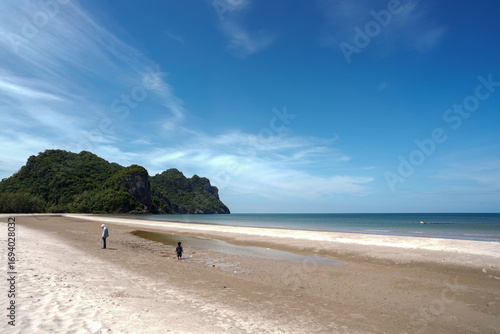 Happy Bar, Thung Yang Beach, Chumphon Province. The boat is moored on a beautiful beach in Thailand and has a blue and white flag.