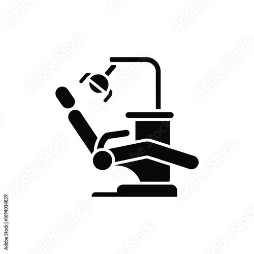 Black and white icon of a dental chair with overhead light