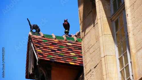 Sculpture d’un chat et d’une chouette sur le toit typique d’une ancienne maison de Dijon en Côte-d’Or France Europe