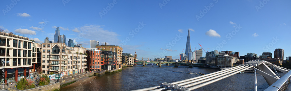 Fototapeta premium Panoramic photo of the River Thames with the Shard skyscraper on the right and Skyscrapers Bank on the left with blue sky and clouds autumn or fall