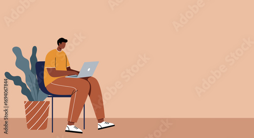 Young man working remotely on laptop at home. Modern digital worker, student, or freelancer focused on online tasks and productivity. Remote work and e-learning concept.