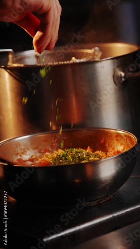 A person is making pasta in a pot. The pot is filled with a red source 