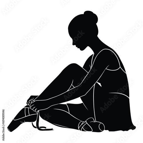 Elegant silhouette of a ballerina tying pointe shoes preparing for dance performance