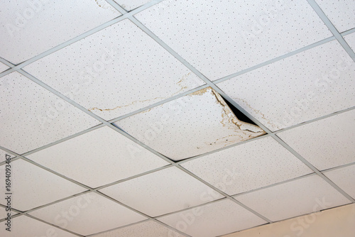 Damaged ceiling tile with water stains and structural failure