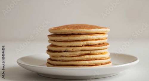 Wallpaper Mural Stack of Golden Circles on a White Dish, Illuminated by Soft, Neutral Lighting. Torontodigital.ca