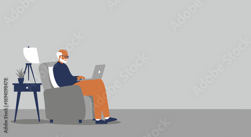 Senior man with glasses and white beard, comfortably using a laptop in an armchair at home, representing modern senior lifestyle, remote work, and digital literacy.