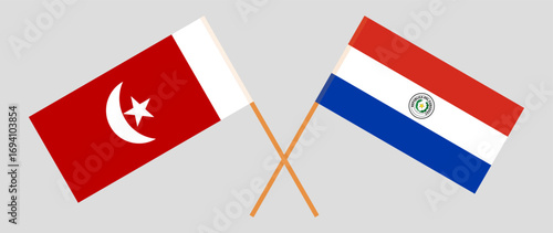 Crossed flags of The Emirate of Umm Al Quwain and Republic of Paraguay. Official colors. Correct proportion. Vector illustration