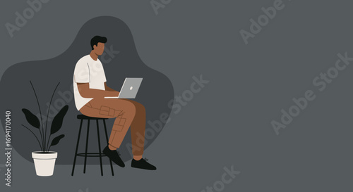 Young man focused on his laptop, working remotely or studying in a modern, casual setting. Perfect for themes of digital work and online education.