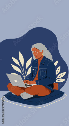 Senior woman with grey hair and glasses sits comfortably, focused on her laptop. Represents digital literacy, remote work, and an active, modern lifestyle for older adults.