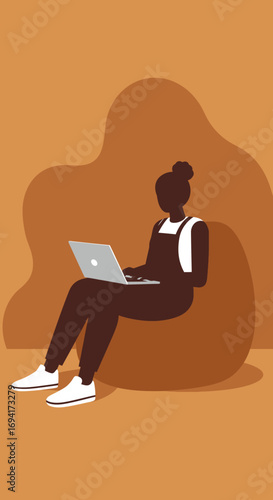 Young woman comfortably working on her laptop from a bean bag chair at home, representing remote work, online education, or digital lifestyle.