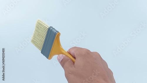 Hand hold paintbrush on isolated white