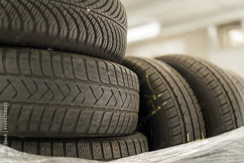 Obraz premium High-quality photo of a stack of used car tires. Perfect for automotive, recycling, or industrial themes. Download now!