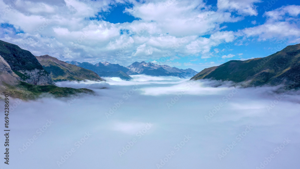 Fototapeta premium Sea of Clouds Flowing Through Mountain Valley