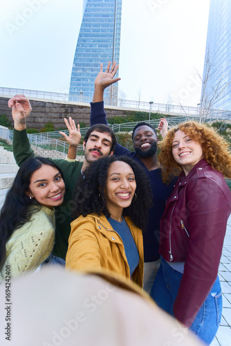 Happy students taking selfie in university campus with skyscrapers in background