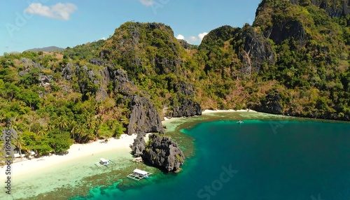 Breathtaking aerial view of tropical beach surrounded by lush greenery in El Nido