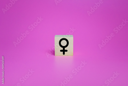 female symbol on wooden blocks isolated on pink background