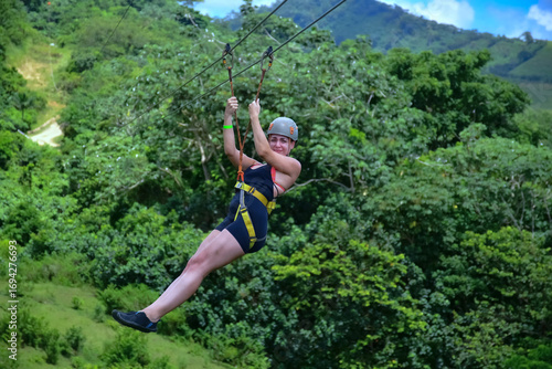 Tourist enjoying zip line adventure in tropical rainforest, punta cana, dominican republic
