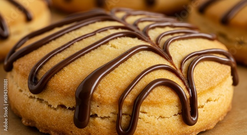 Freshly baked donut with chocolate drizzle close up view isolated on a wood table
