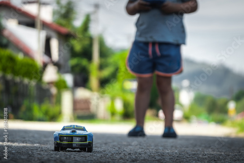 Wallpaper Mural Boy drives a remote-controlled toy car outside Torontodigital.ca