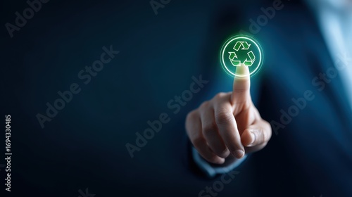 Businessman touching glowing recycling symbol with finger
