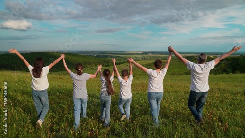 Happy family team holding hands raising hands in park. Teamwork of people. Group of people of different ages traveling. Business, Partnership help. Family business. Family picnic nature parents kids