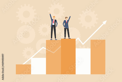 Two businessmen celebrating success standing on a bar chart with upward trending graph and gears in background