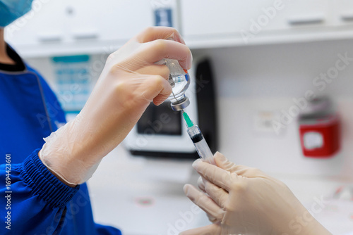 Tapet Healthcare professionals preparing syringe with vaccine from vial in clinical se