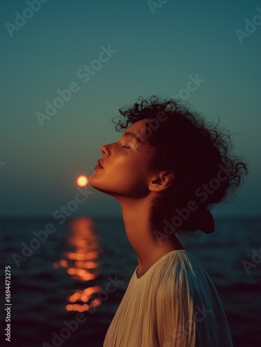 A serene portrait of a woman gazing toward the sunset over water, capturing a moment of tranquility and reflection.