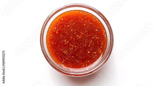 Overhead view of sweet chili sauce in a clear glass bowl on white table
