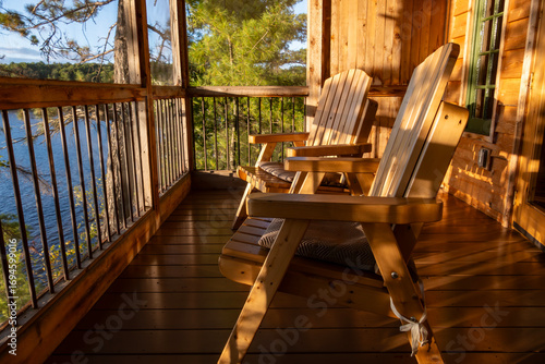 A Couple of Adirondack Chairs in a Covered Porch of a Cottage Overlooking French River in the Late Afternoon Sun