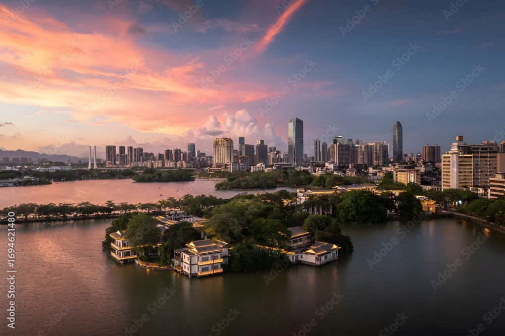 Fototapeta premium Luxury Waterfront Villas and Modern Skyscrapers Reflected in Calm Lake Waters Under Dramatic Colorful Sunset Sky