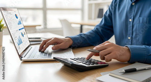 Professional analyzing financial data with laptop and calculator