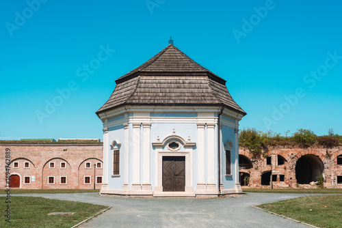 Old chapel with wooden roof in fortress complex under clear blue sky. Slavonski Brod, Croatia