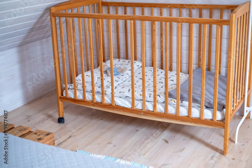 Wooden crib with soft bedding and pillows, positioned in a cozy nursery, featuring light wooden flooring and a serene atmosphere for a child's restful environment