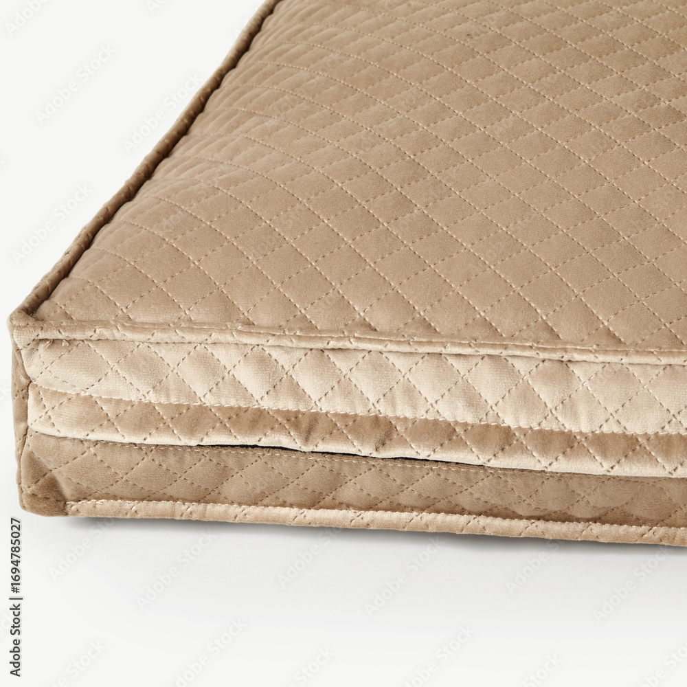 Naklejka premium Beige velvet cushion showing quilted pattern and seam